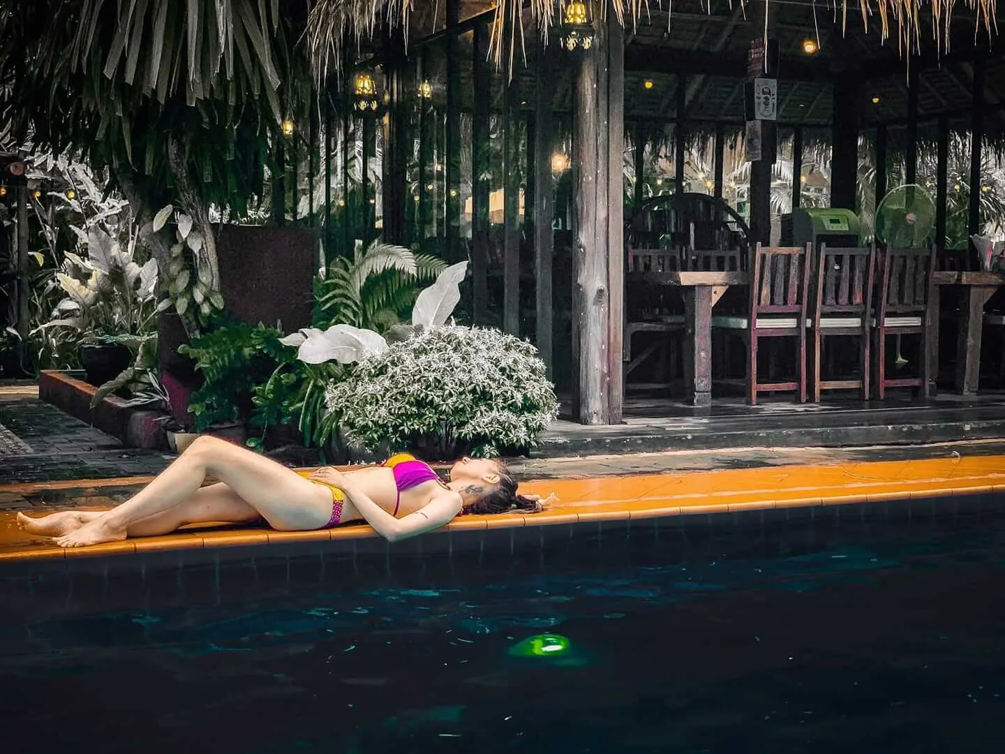 Floating at the edge of the pool after dark