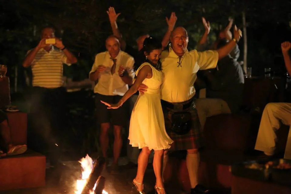 Guests dancing around a fire at night