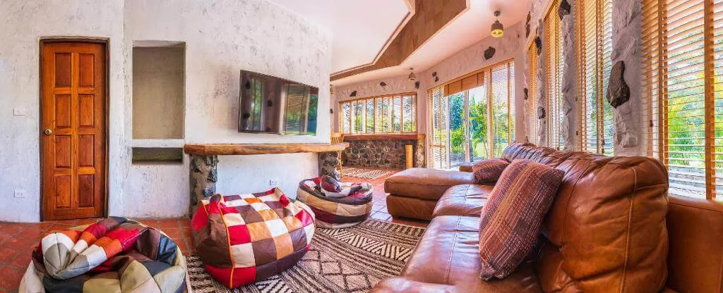 The living area, with the television and floor cushions under the stone walls