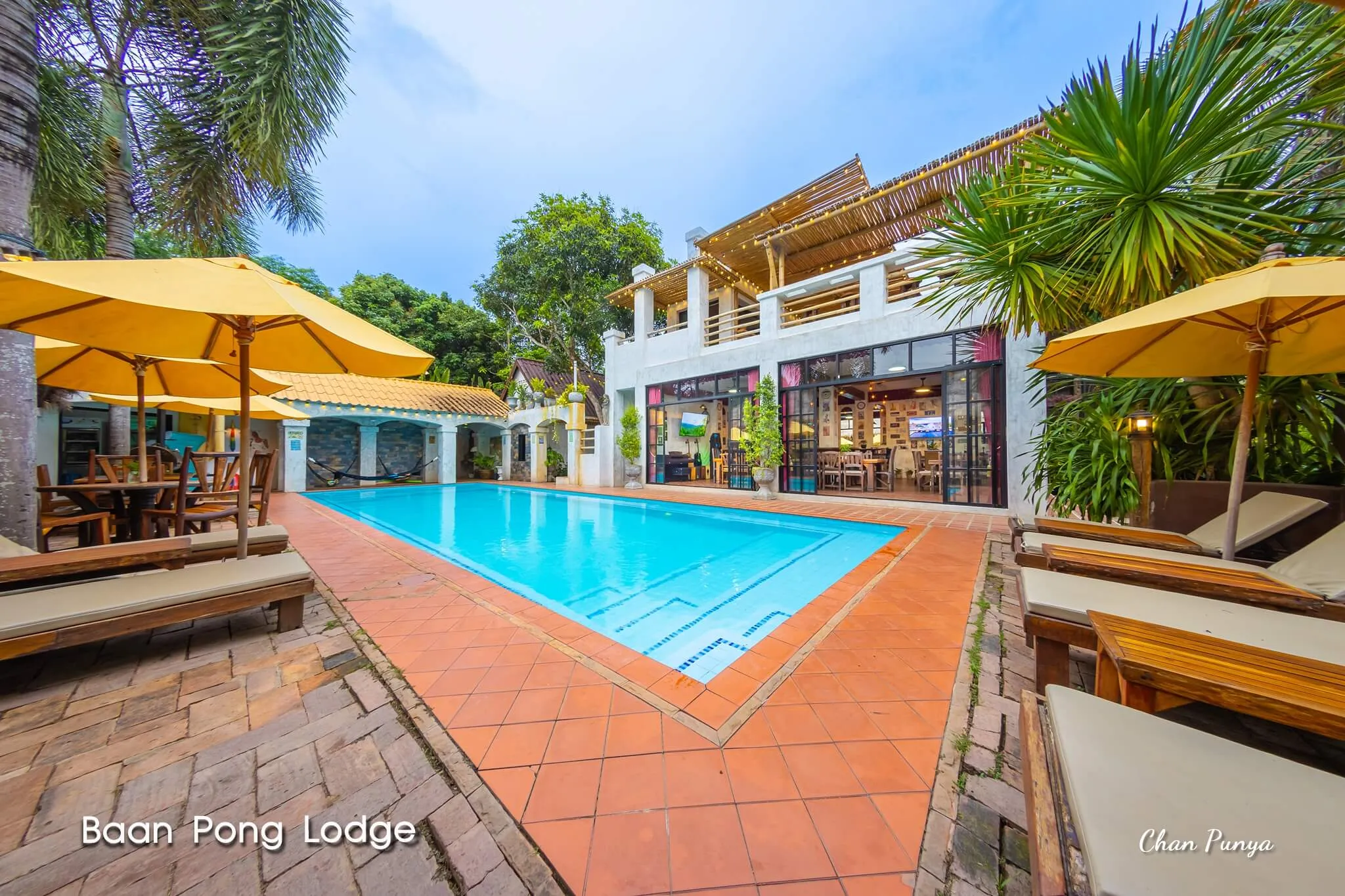 The pool in the afternoon, yellow umbrellas along the terrace