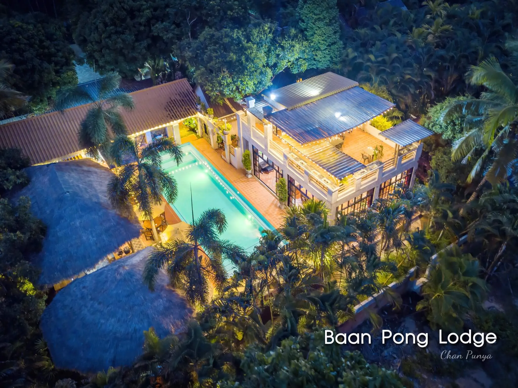 The lodge and its pool from the air at night