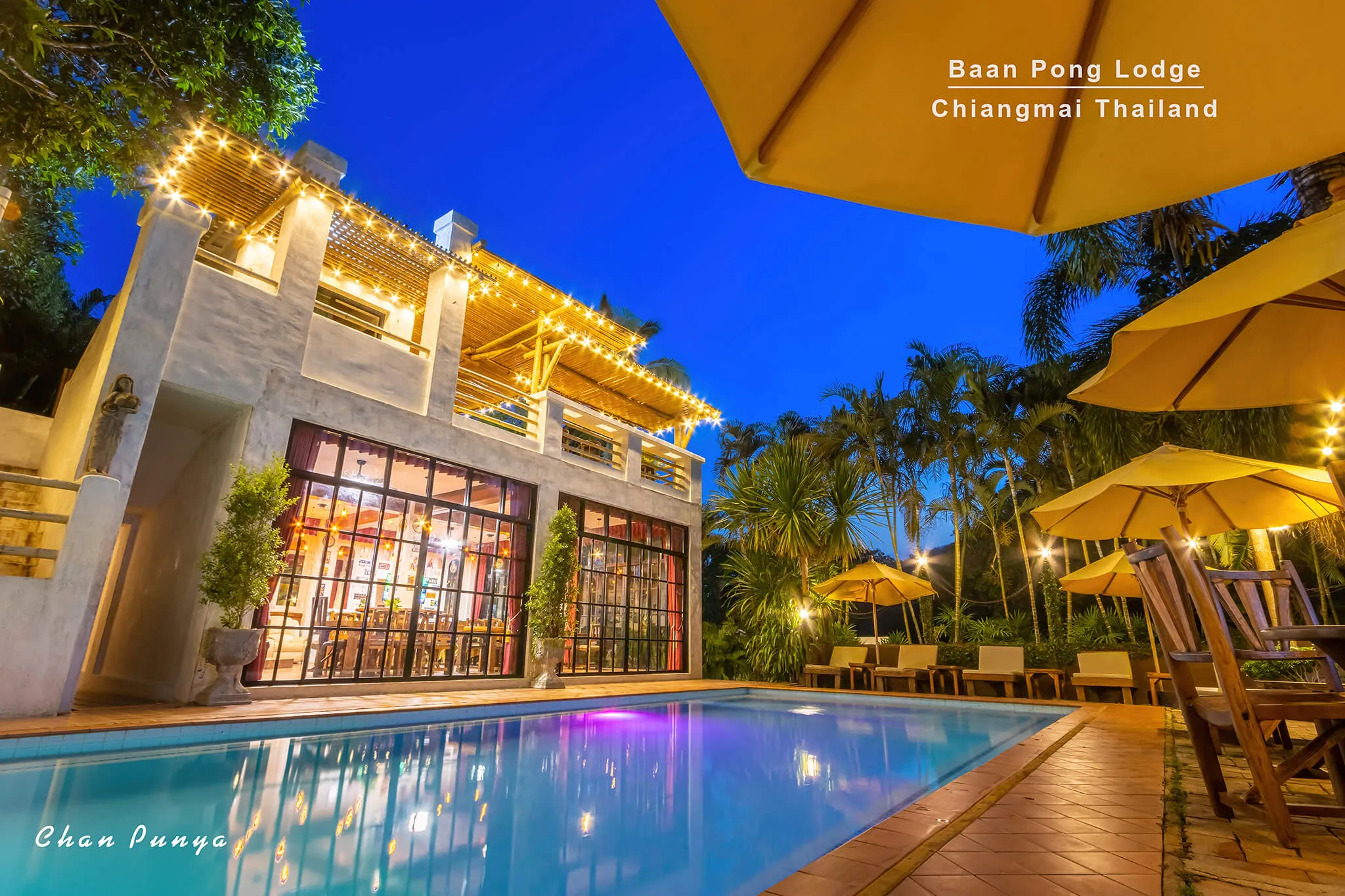 The pool at blue hour, umbrellas up and the restaurant glowing