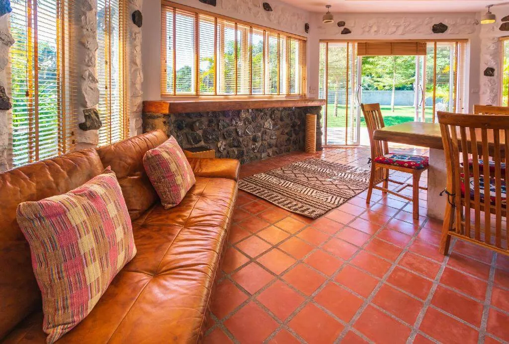 The living room, with a leather sofa and the doors open to the outside