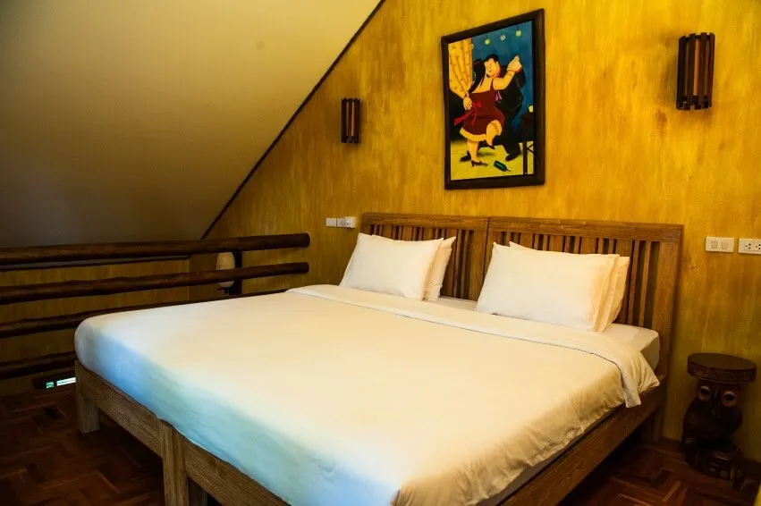 A king bed beneath a painted panel