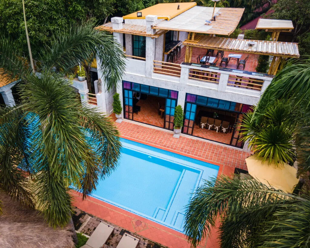 The pool and the lodge building from above, in the palms