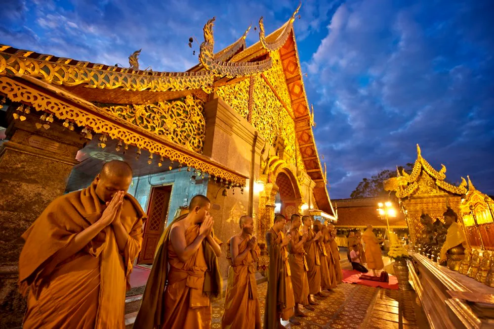 พระสงฆ์รวมตัวกันอยู่หน้าวิหารปิดทองที่วัดพระธาตุดอยสุเทพยามพลบค่ำ