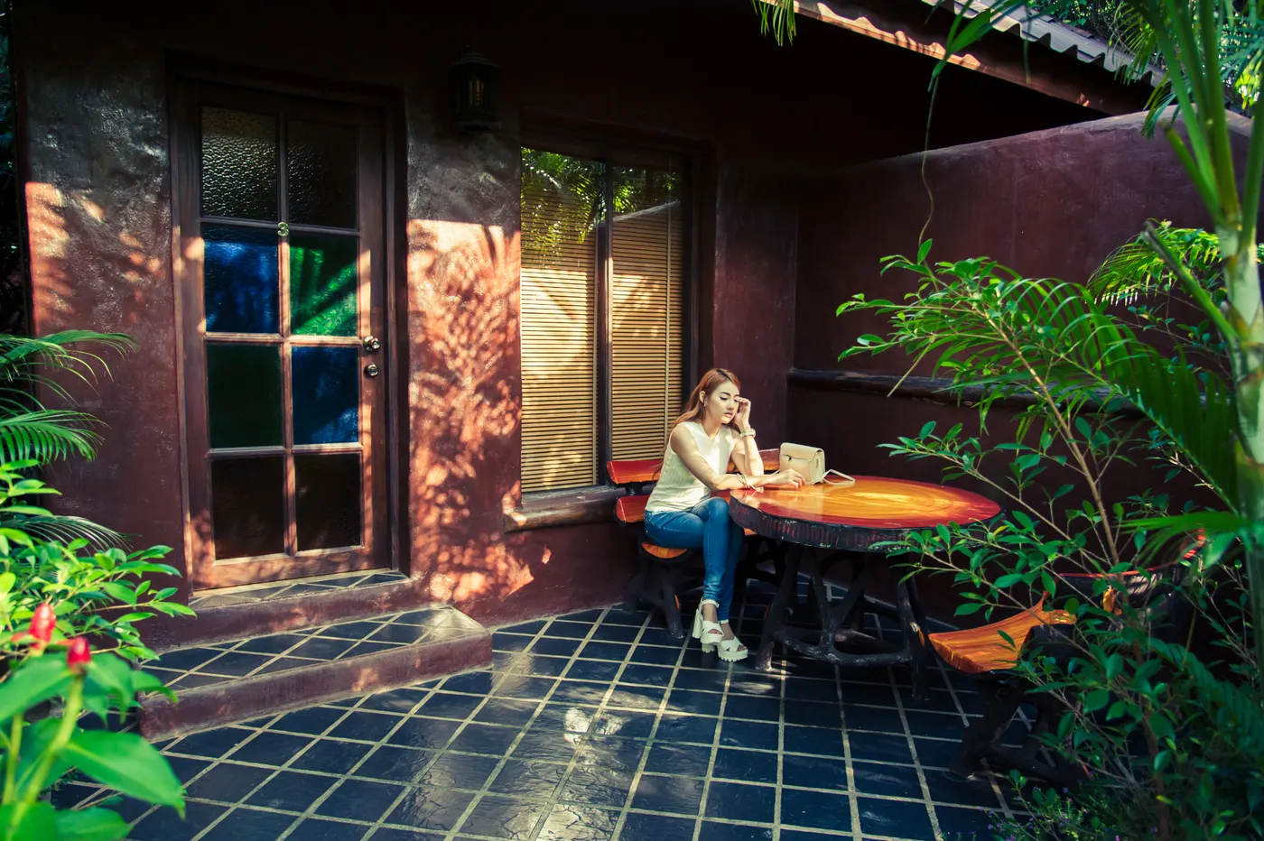 A guest at the table on a chalet terrace, under the trees