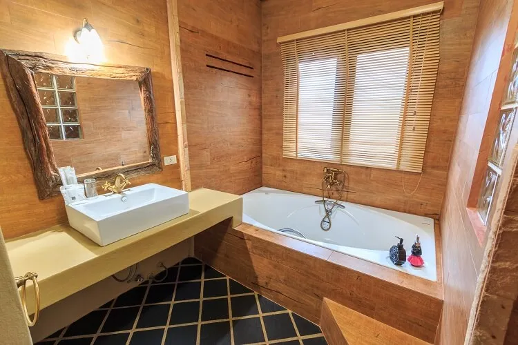 The bathtub and basin in the wood-lined bathroom