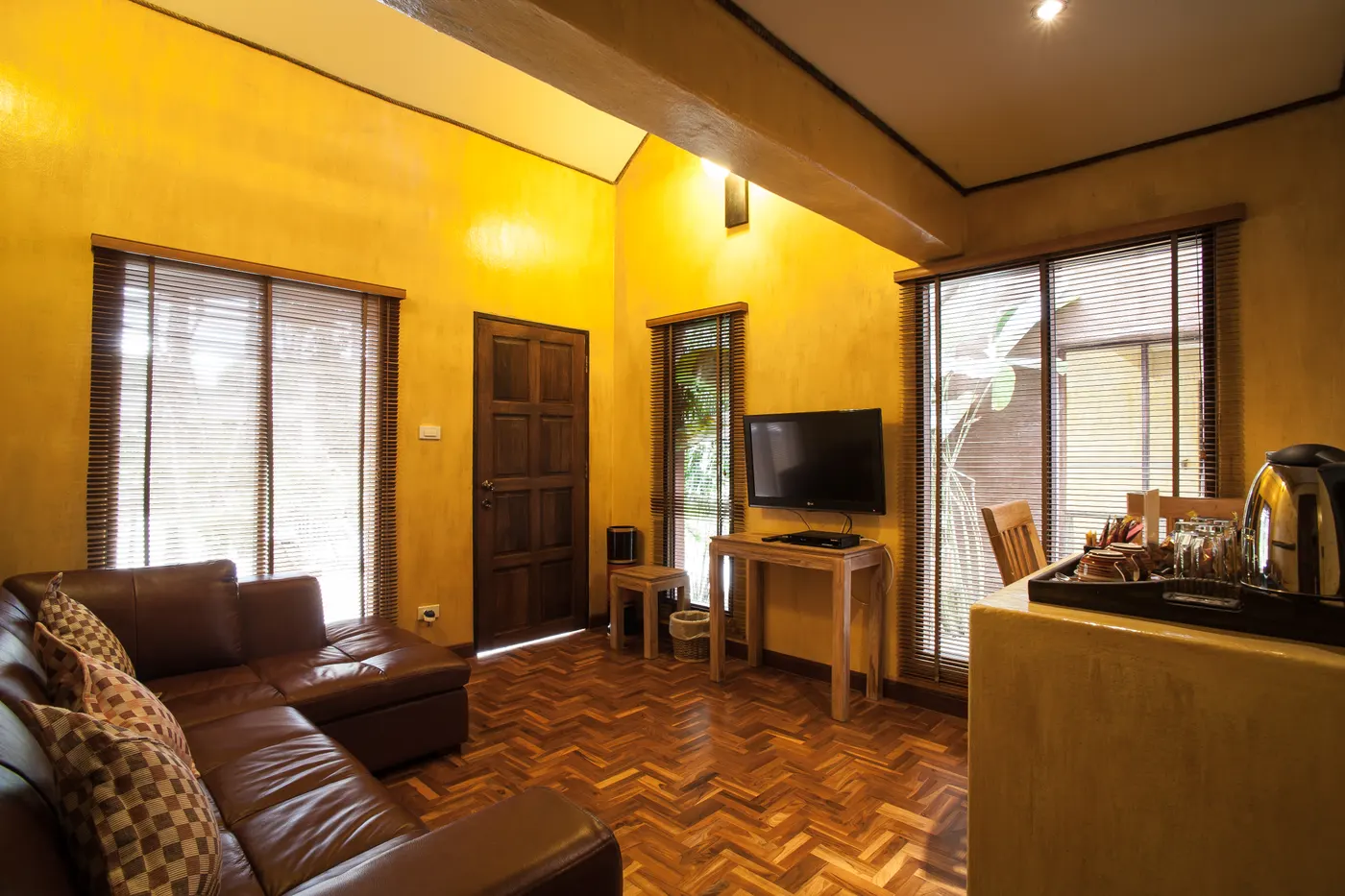 The lounge of a loft chalet, with a leather sofa, a television and a desk