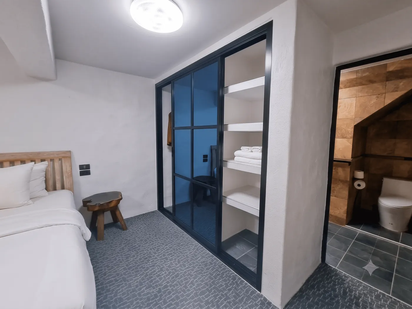The glazed closet of folded towels, next to the bathroom
