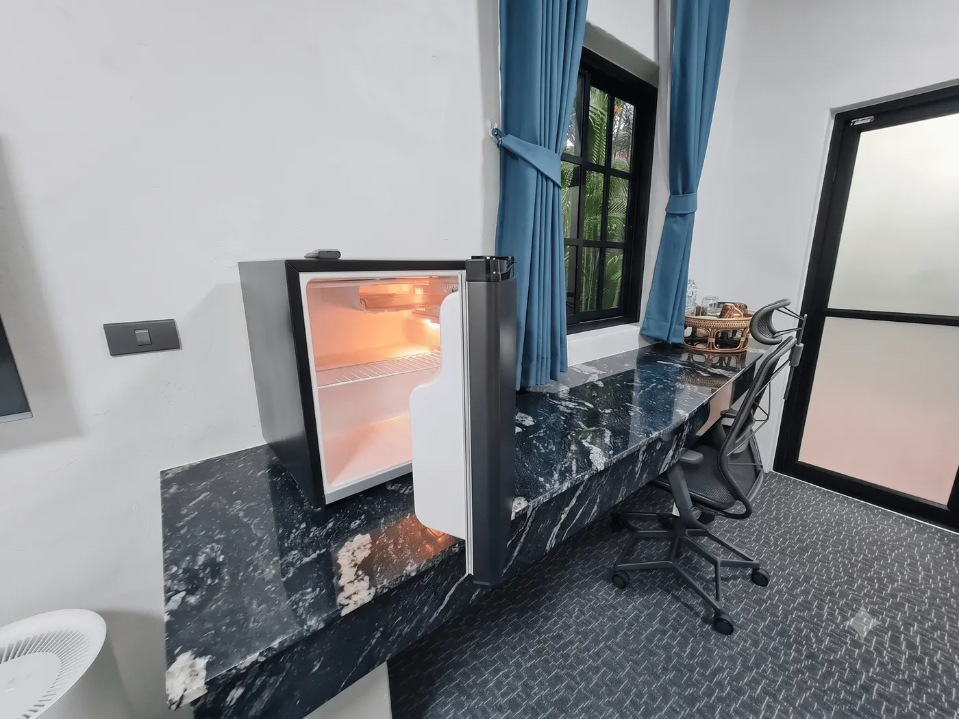 The work desk along the marble ledge, with a chair at the window