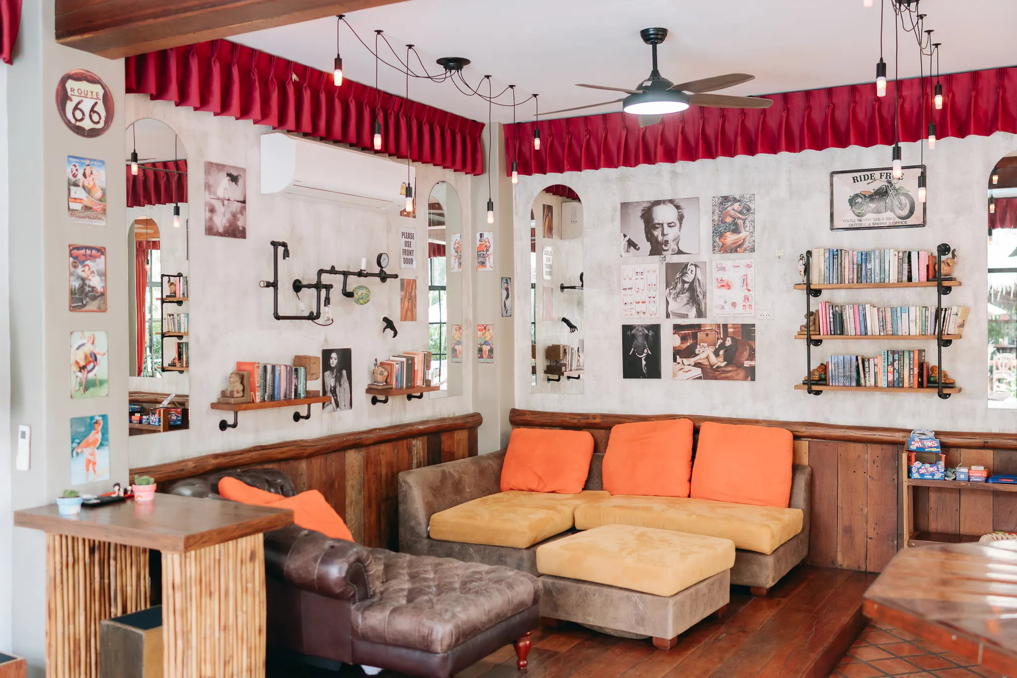 The bar room under its red pelmets, ceiling fans and old road signs