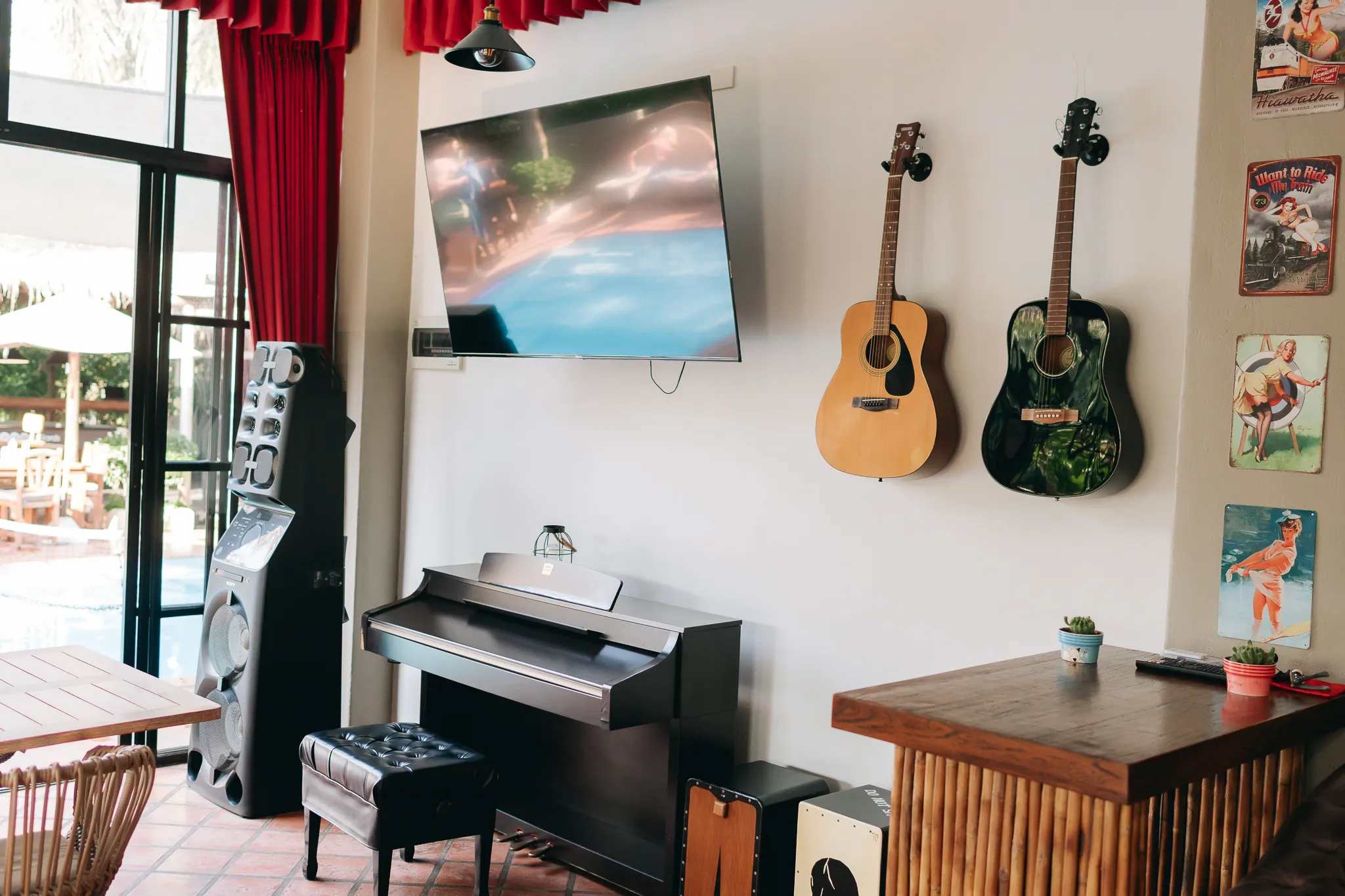 The lounge, a piano and two guitars on the wall, the pool through the doors